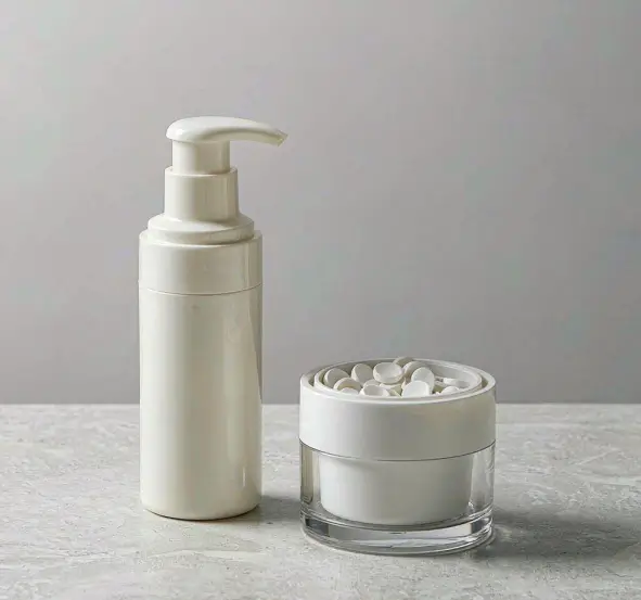 Airless pump dispenser and a glass jar of toothpaste tablets on a light surface