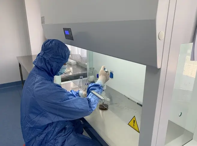 Quality control technician inspecting a filled toothpaste tube in the laboratory